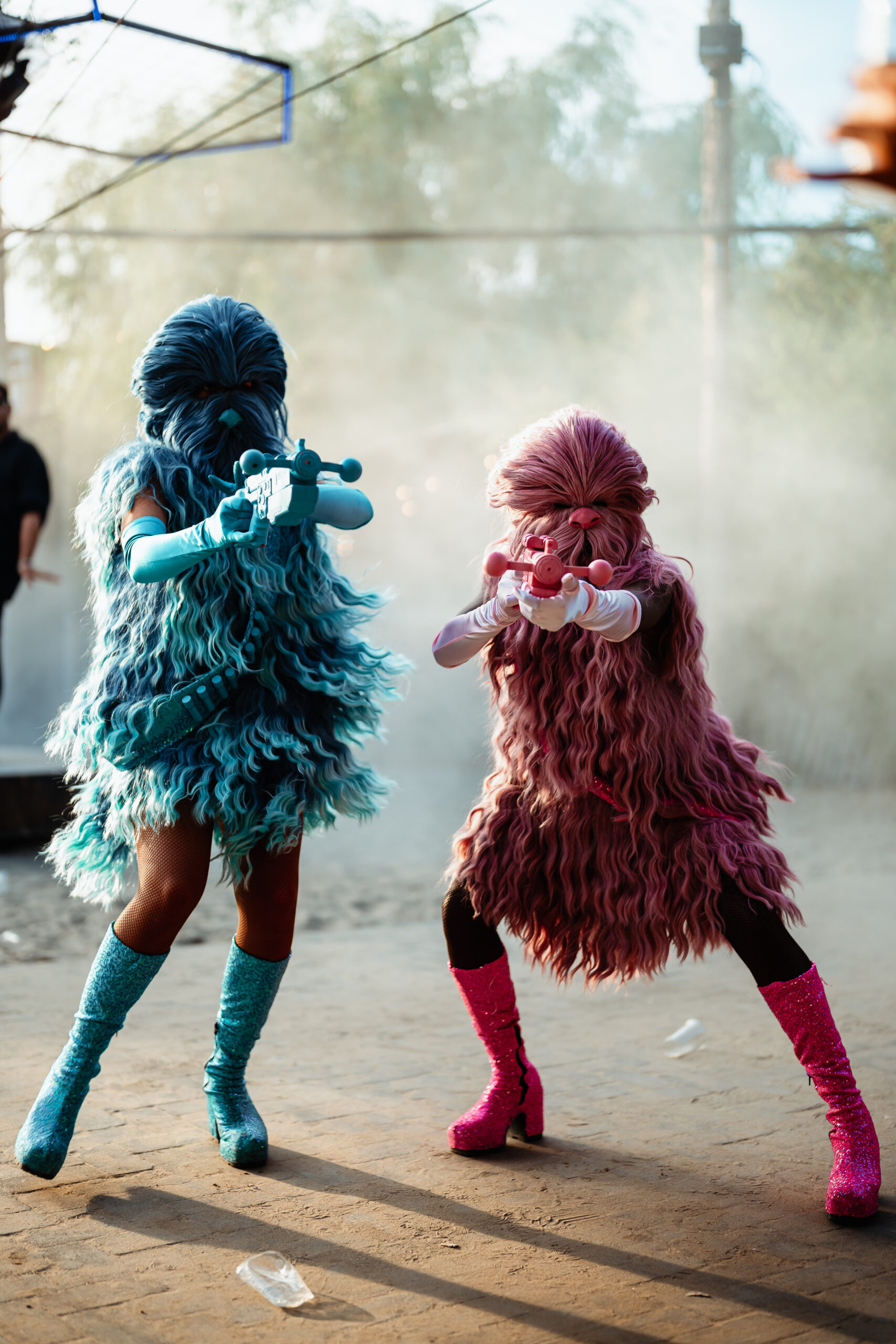 Twee performers in harige alien-achtige kostuums met waterpistolen.