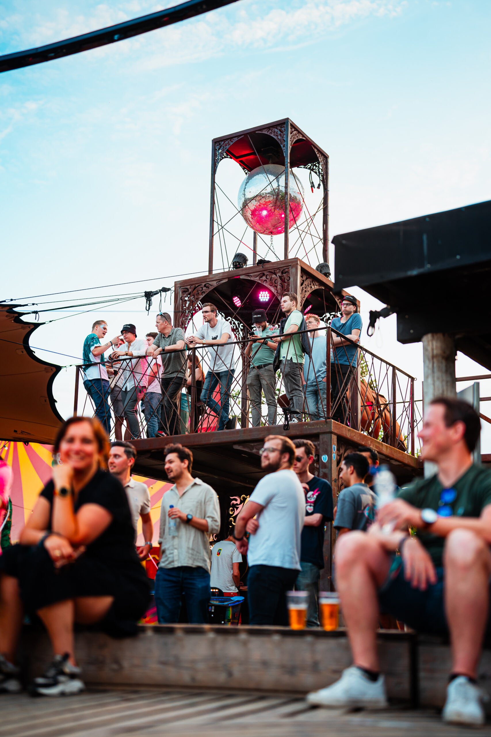 Publiek kijkt vanaf verhoogd platform met discobal.