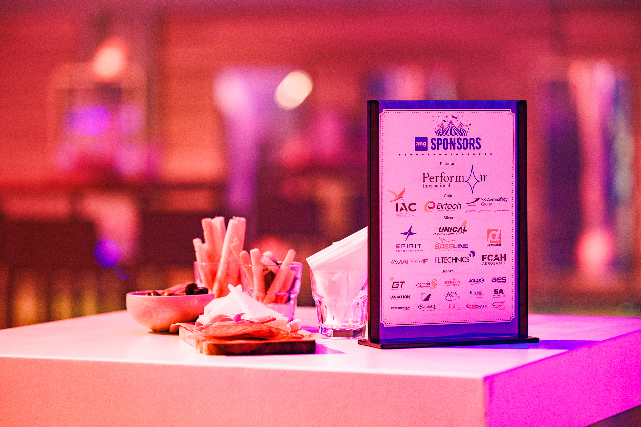 Sponsorbord met logo’s van partners en sponsors tijdens het ANG netwerkevent, gepresenteerd op een stijlvol gedekte tafel.