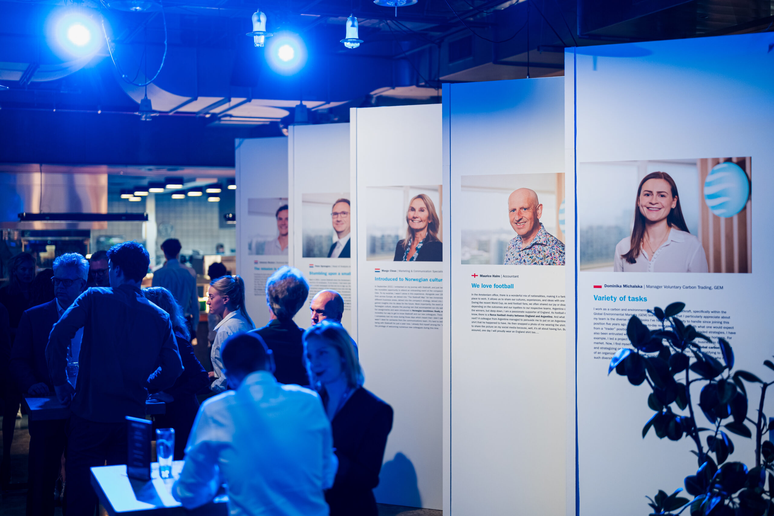 Informatiestands met Statkraft-medewerkers en verhalen tijdens het 25-jarig jubileumevenement, omringd door bezoekers.