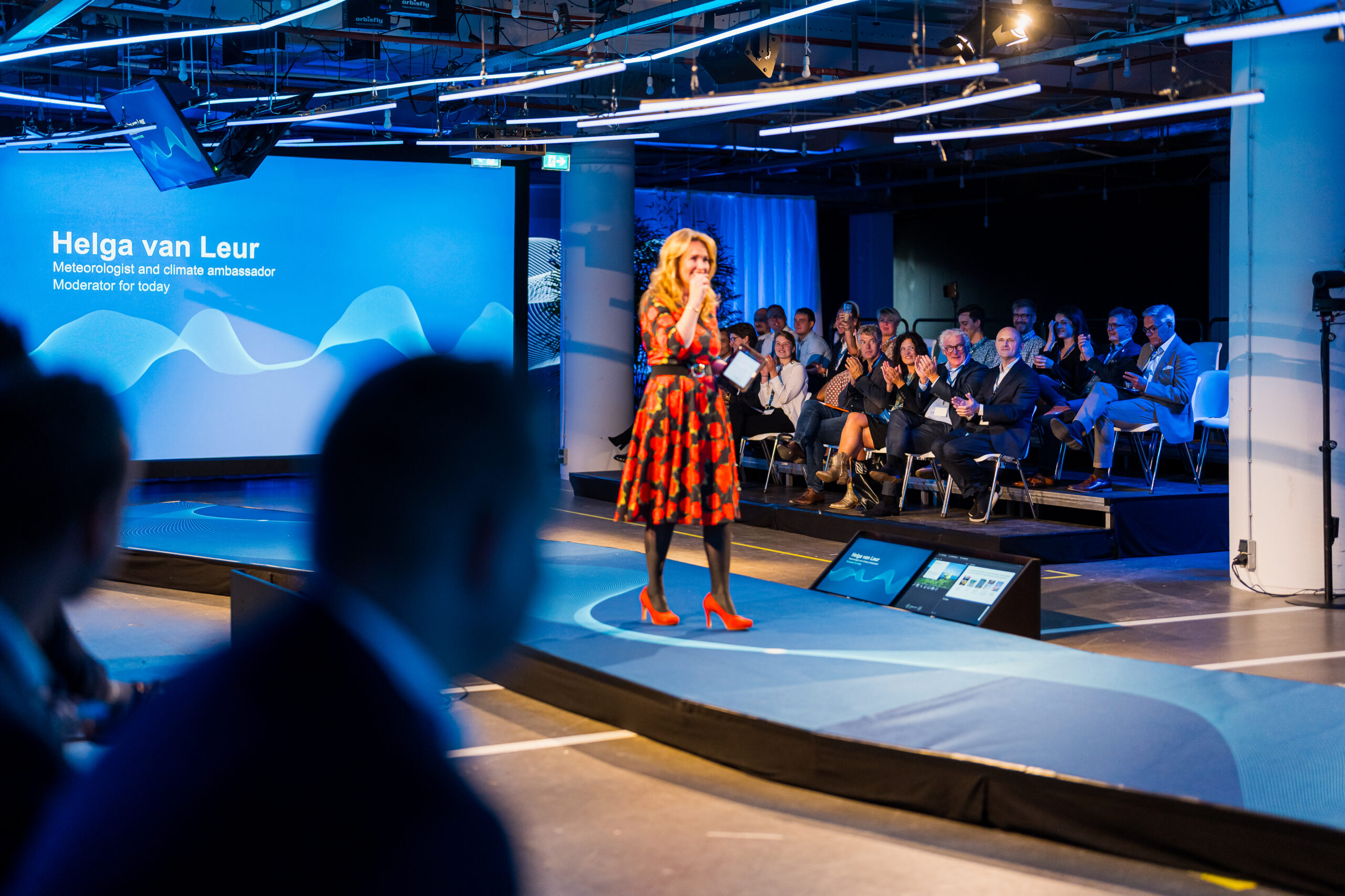 Helga van Leur spreekt op het podium tijdens het Statkraft 25-jarig jubileumevenement, met een publiek van medewerkers en gasten.