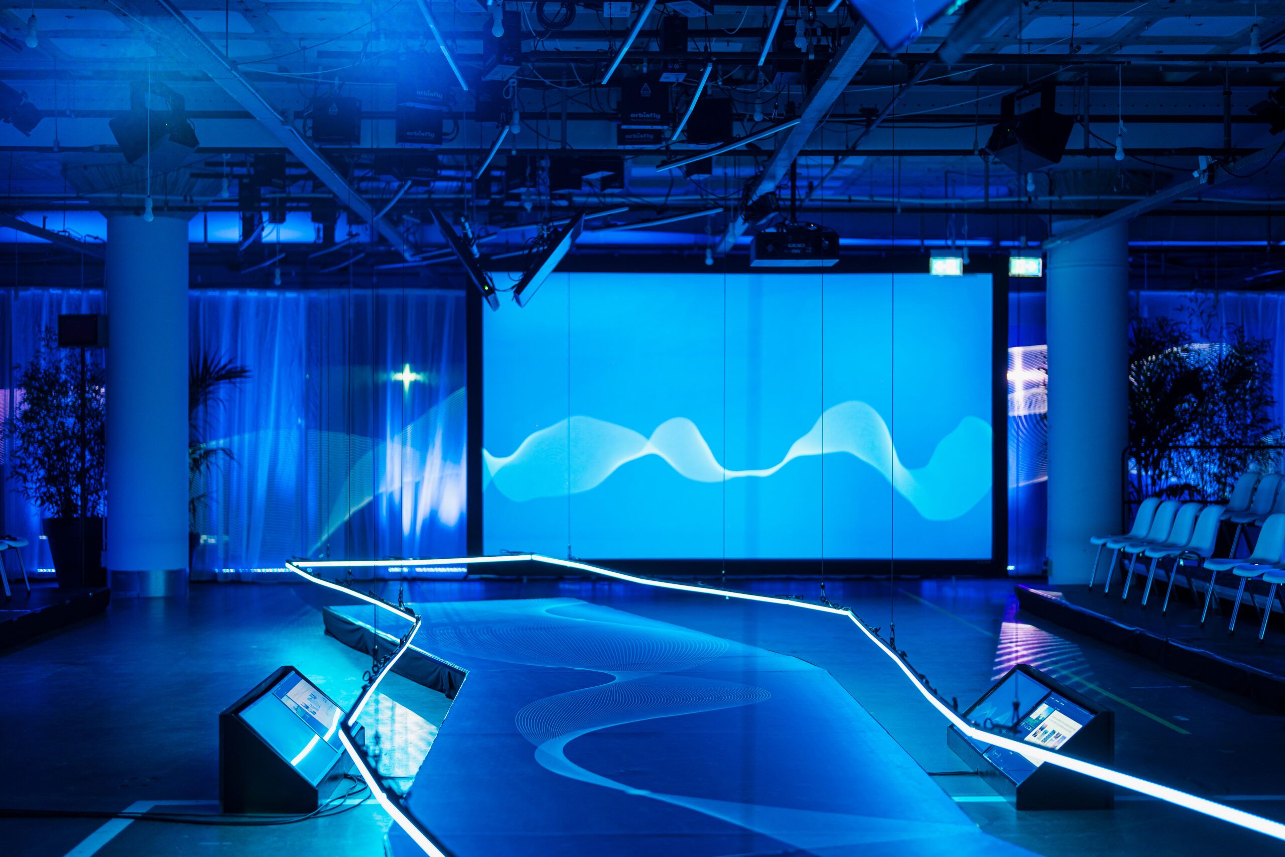 Verlichte blauwe podiumsetting met futuristisch design, gebruikt tijdens het Statkraft 25-jarig jubileum georganiseerd door Dutch Standard Events.