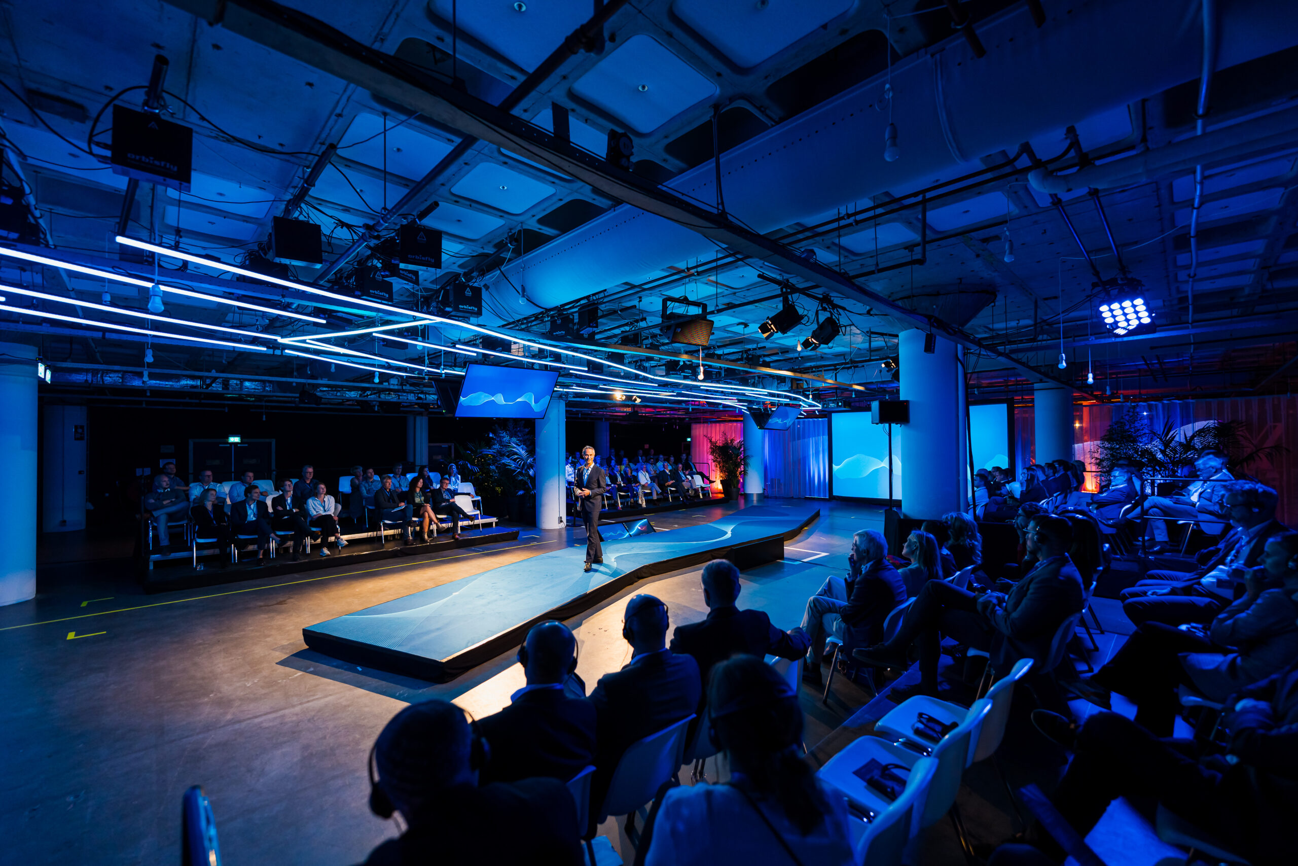 Presentatie op een futuristisch podium met blauwe verlichting tijdens het Statkraft 25-jarig jubileumevenement.