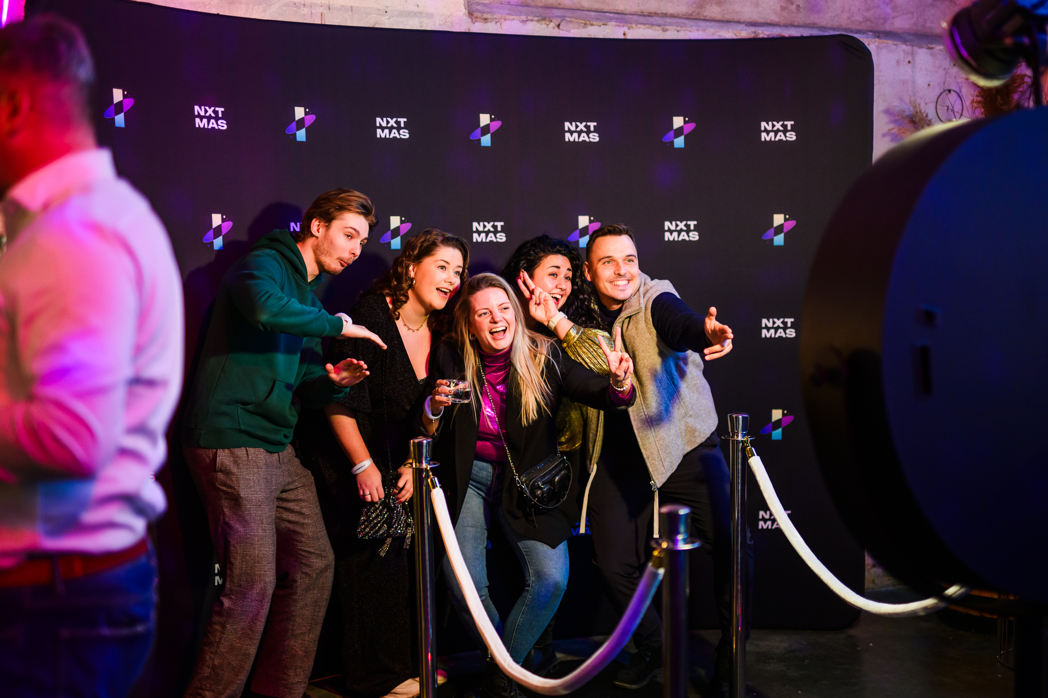 Een groep vrienden poseert enthousiast bij een photobooth.