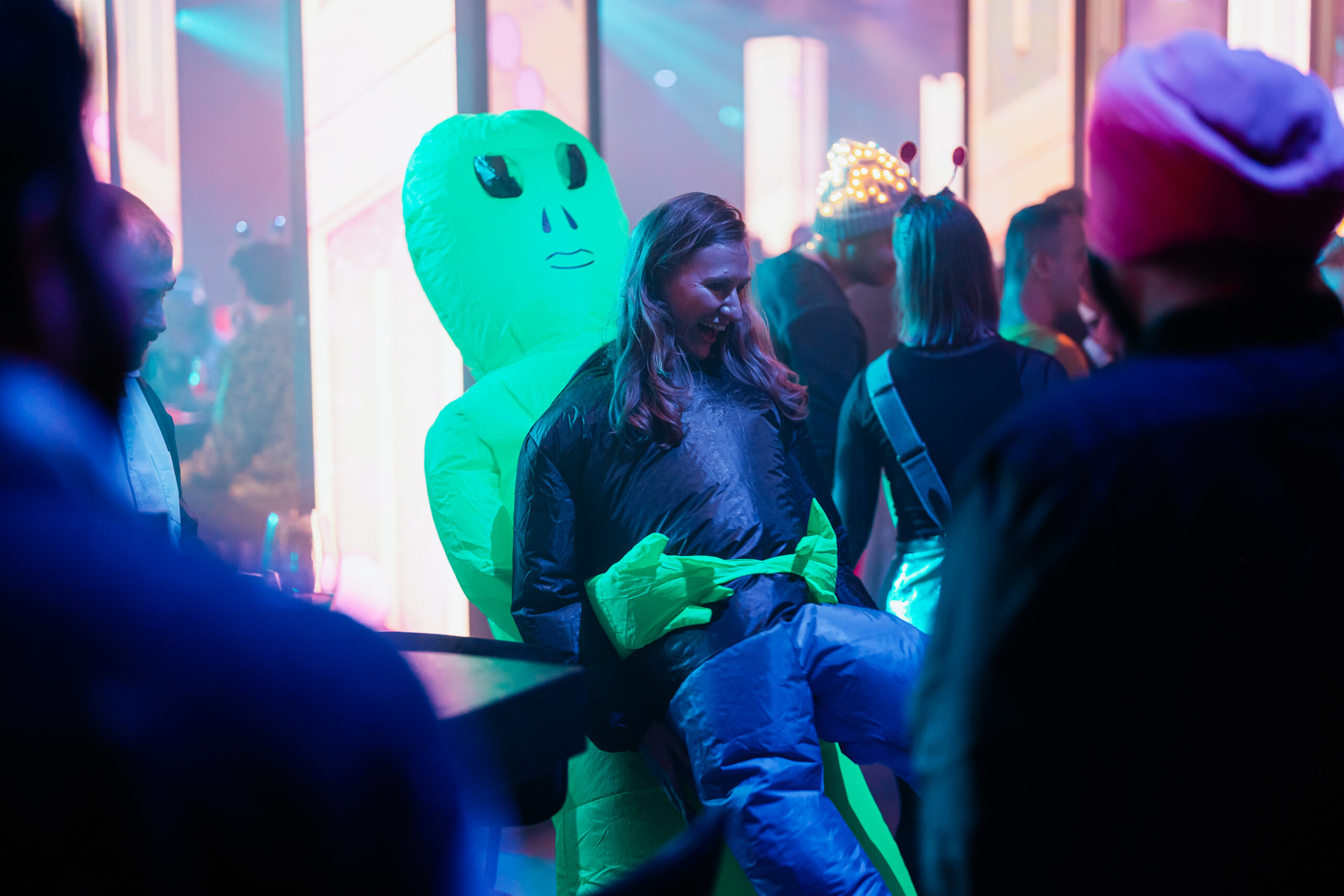 Deelnemer gekleed in een creatief alienpak tijdens een themafeest.