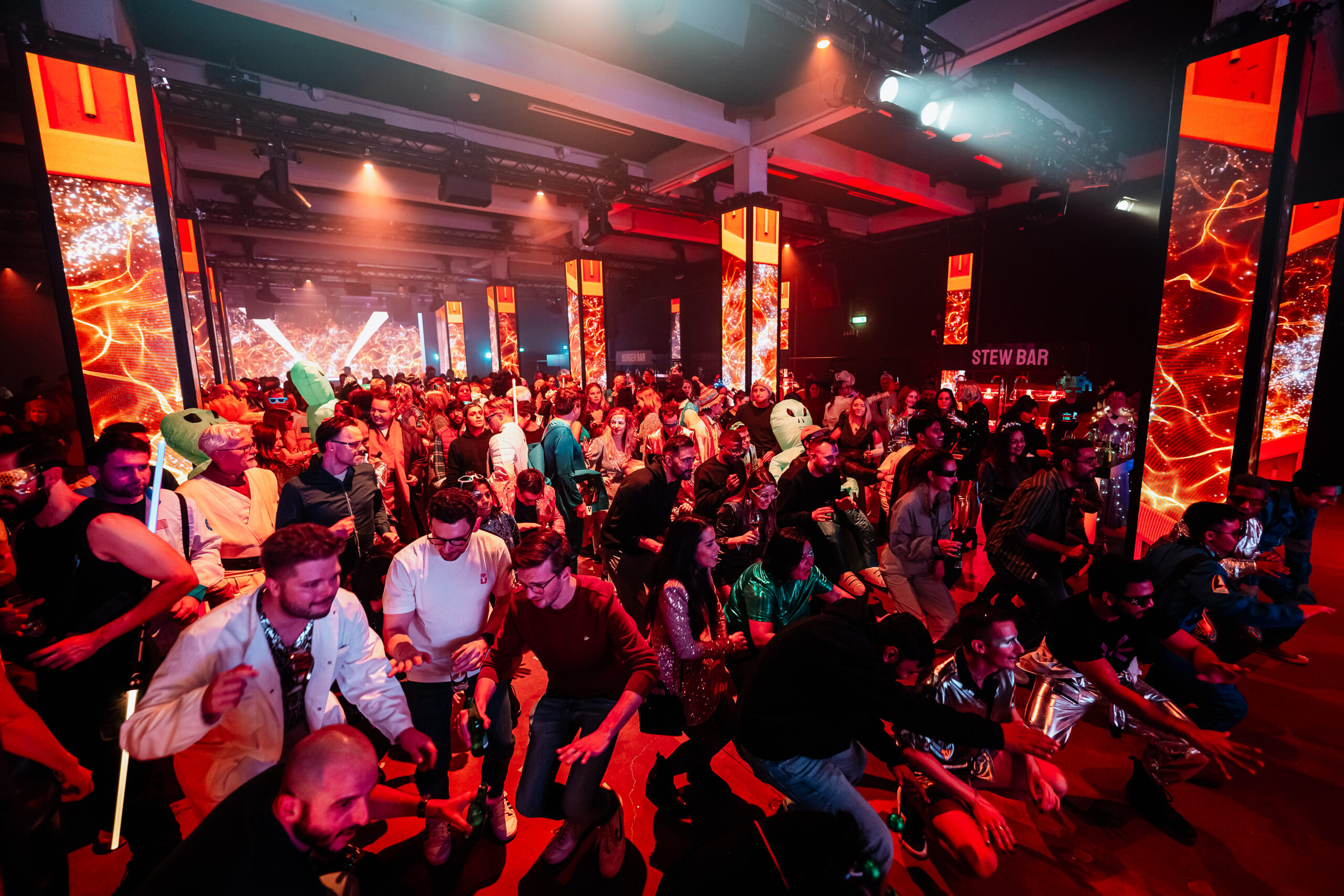 Grote groep feestgangers geniet van een interactief moment tijdens een themafeest.